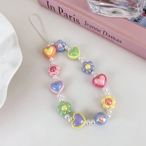 Détail d'une dragonne de téléphone en perles colorées avec cœurs et fleurs