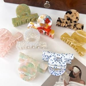 Detailed close-up showing seven colorful acetate hair claws with marble and tortoiseshell patterns