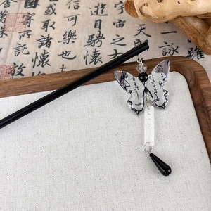 Detalle de un pasador de pelo de mariposa de estilo chino con borlas en bandeja de madera
