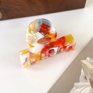 Close-up of artistic acetate hair claw with vibrant oil painting mixed color pattern