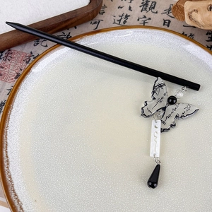 Detalle del pasador para el pelo de mariposa con patrón de tinta y colgante blanco