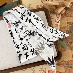 Detail of silk scarf showing Chinese ink wash bamboo pattern and calligraphy on wood tray