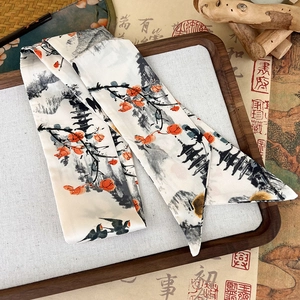 Detailed macro shot of ink wash art twilly scarf on traditional wooden tray