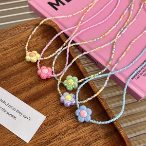 Colliers de perles colorées avec pendentifs fleurs en rose jaune bleu vert et violet