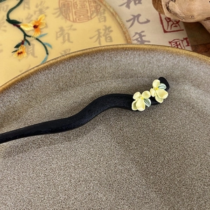 Close-up of ebony wood hair stick featuring delicate jasmine and gardenia flowers
