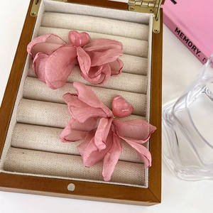 Close-up of pink chiffon butterfly earrings with heart resin beads in a jewelry box