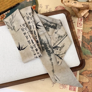 Detail shot of ink landscape silk scarf on vintage scroll and wooden tray setting