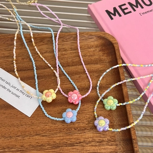 Cinq colliers de fleurs colorées en acrylique sur un plateau en bois pour femmes