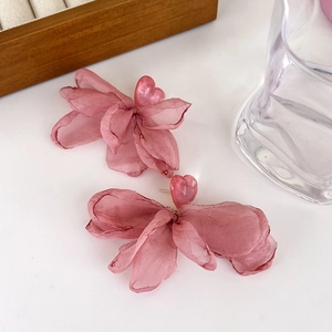 Detailed macro view of soft rose pink chiffon flower earrings with heart-shaped center beads