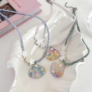 Star and shell beaded necklace with colorful sequins and pearls in a seashell tray