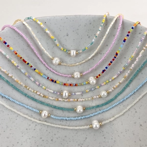 Close-up of handmade colorful seed bead necklaces with baroque freshwater pearl detail