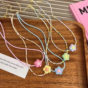 Détails de colliers en perles colorées avec pendentifs fleurs en acrylique et fermoirs dorés