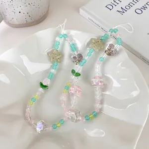 Bijou de téléphone perles tulipes pastel avec étoiles et cœurs dans un plateau blanc