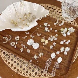 Elegant floral and pearl earrings set with vintage aesthetic on a decorative tray