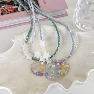 Detailed macro view of Y2K star shell beaded necklaces set with colorful glitter accents