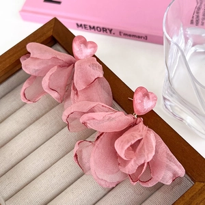 Macro detail of sweet pink heart earrings with layered chiffon petals in a jewelry box