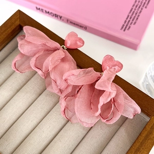 Detail view of pink rose heart chiffon fabric petal earrings on a jewelry tray