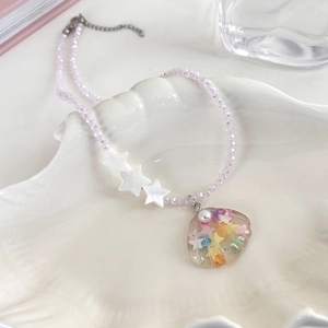 Detail of pink crystal bead necklace with star accents and glitter shell pendant