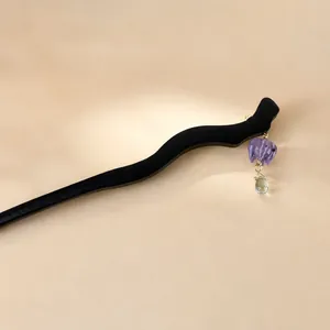 Handmade lily of the valley wood hair pin with purple charm on a silk fan background
