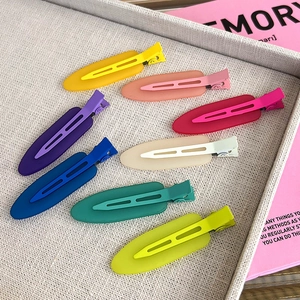 Eight colorful matte seamless hair clips in a grey tray with a fresh aesthetic background