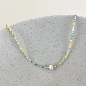 Detail of colorful beads and a freshwater baroque pearl on a stylish collar necklace