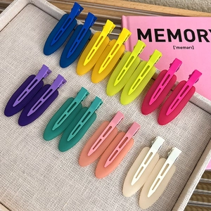 Flat lay of 16-piece matte jelly colored seamless hair clips in a fabric tray