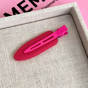 Close-up of a matte rose red traceless hair clip with a duckbill design and metal base