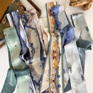 Detail of silk scarves featuring traditional Chinese landscape and crane prints on wood tray