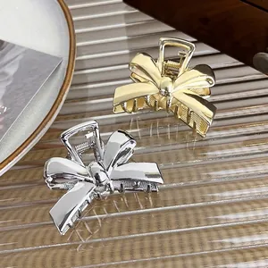 Elegant polished metal bow hair claws in gold and silver finish for women's hairstyling