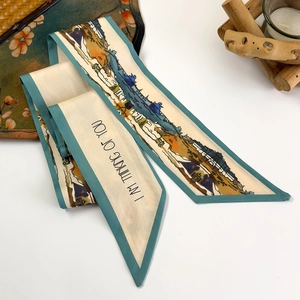 Macro shot of an ivory twilly silk scarf with abstract mountain prints and blue edges