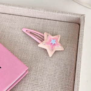Dettaglio del fermaglio a stella Y2K con strati di resina rosa e piccola stella blu