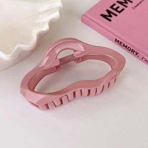 Macro view of pink irregular cloud hair claw clip with glossy acrylic finish
