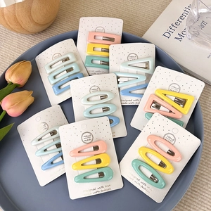 Sets de barrettes à cheveux géométriques aux tons macaron pastel sur un plateau décoratif