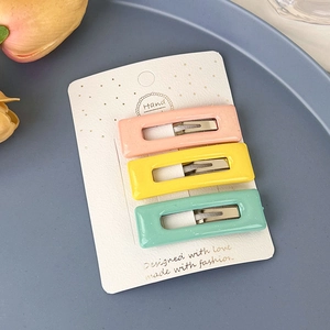 Détail de trois barrettes rectangulaires aux couleurs pastel sur carte de support