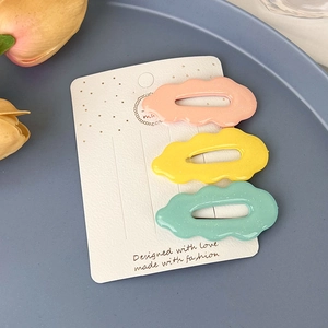 Détail de barrettes à cheveux ondulées aux couleurs de bonbons sur carte et plateau