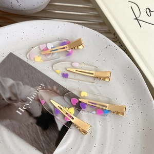 Set of four transparent acrylic hair clips with colorful glitter hearts and gold metal base