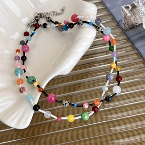 Detail of dopamine style colorful beaded necklace with silver lobster clasp on a shell tray