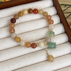 Primo piano del bracciale multistrato in perline di agata con ciondolo a fiore verde