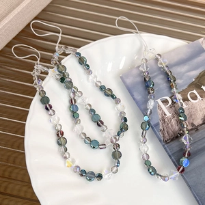 Macro view of glittering multi-colored crystal beaded phone charm on a tray