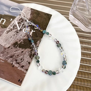 Detailed macro view of colorful faceted crystal beads and flower charms on phone lanyard