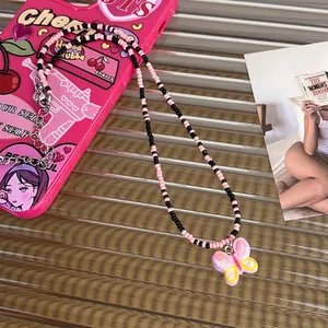 Pink and black beaded Y2K necklace with a butterfly resin pendant and silver metal clasp