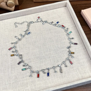 Détail du collier argenté avec cristaux rectangulaires colorés et pompons en zircon