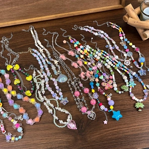Vue à plat de colliers de perles Y2K colorés avec breloques cœur et étoile sur bois