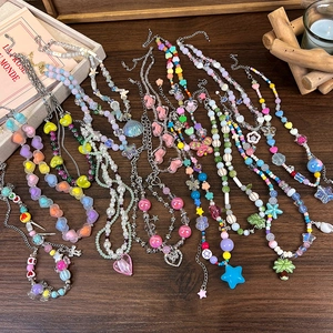 Détail de colliers de perles de style Y2K avec des breloques cœur, étoile et coquillage