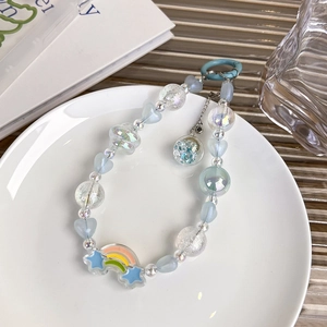 Détail des perles cœur bleues et boule en verre sur cette dragonne de téléphone stylée