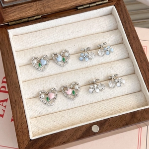 Détail de boucles d'oreilles tulipe en forme de cœur dans une boîte à bijoux en bois