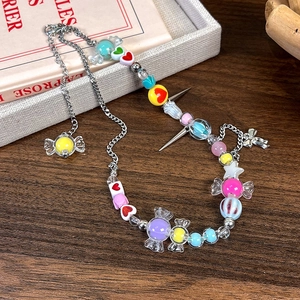 Détail d'un collier de perles Y2K coloré avec des étoiles et des cœurs sur bois