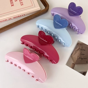 Pinces à cheveux brillantes en forme de cœur roses, bleues et violettes sur plateau