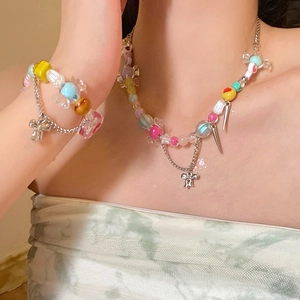 Détail de l'ensemble collier et bracelet en perles colorées avec pendentifs sur modèle