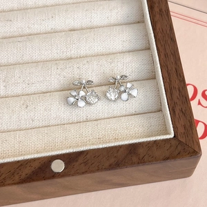 Détail des boucles d'oreilles tulipes en argent avec zircon et perle dans un écrin à bijoux